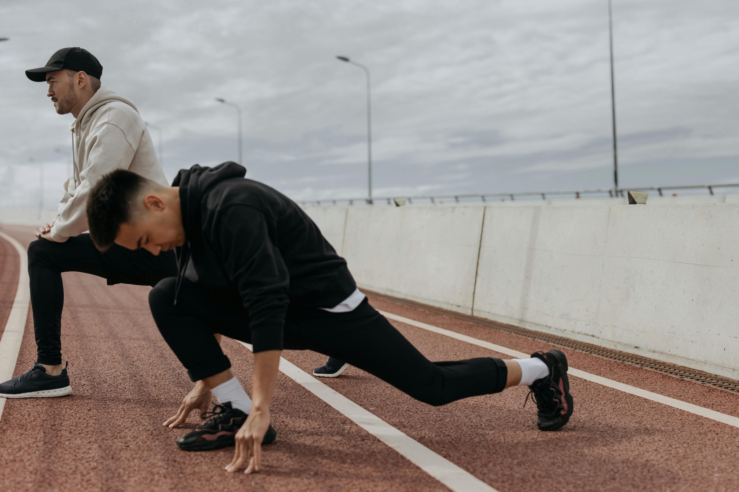 two men doing stretching before a run