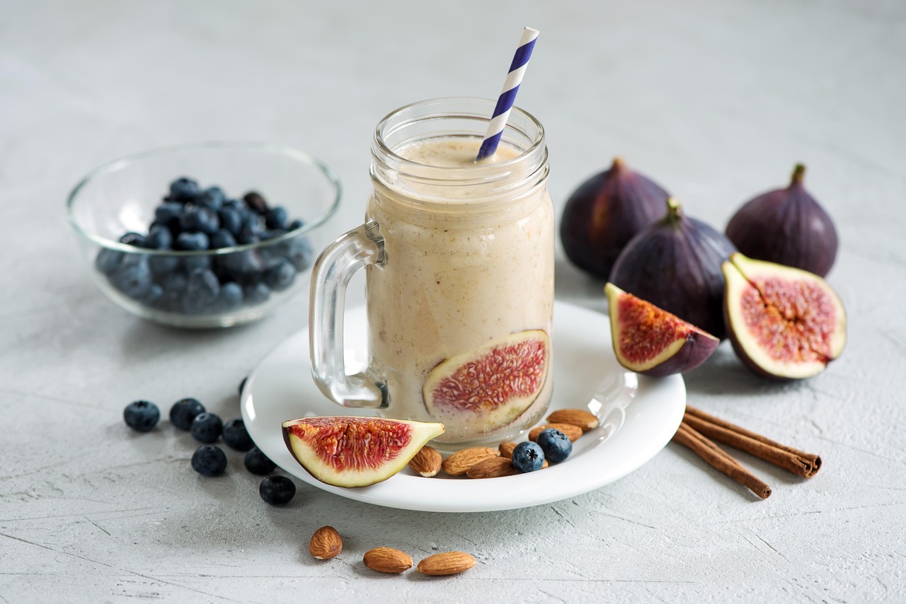 smoothie in a mason jar surrounded by berries and nuts