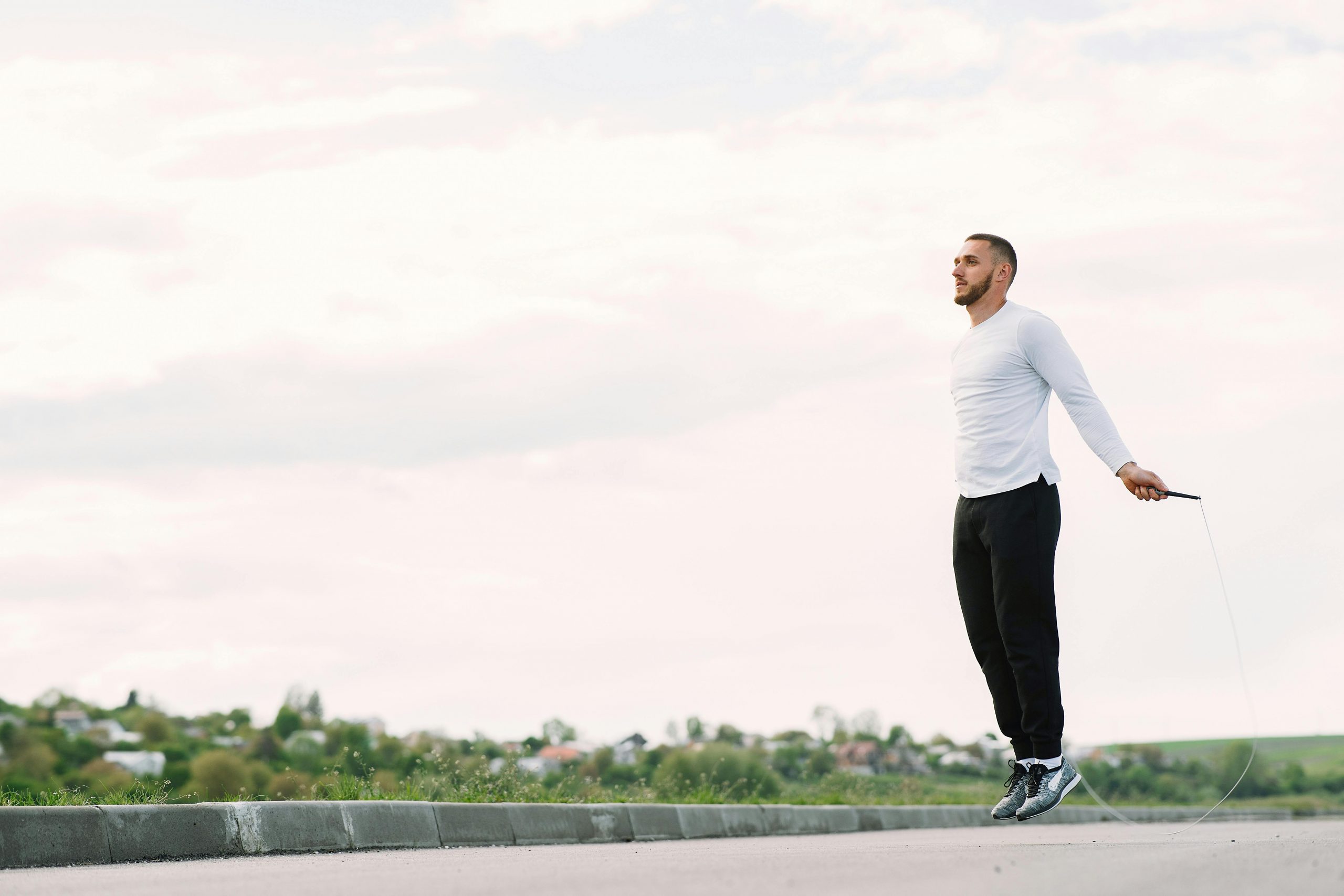 man exercising with a jump rope outdoors