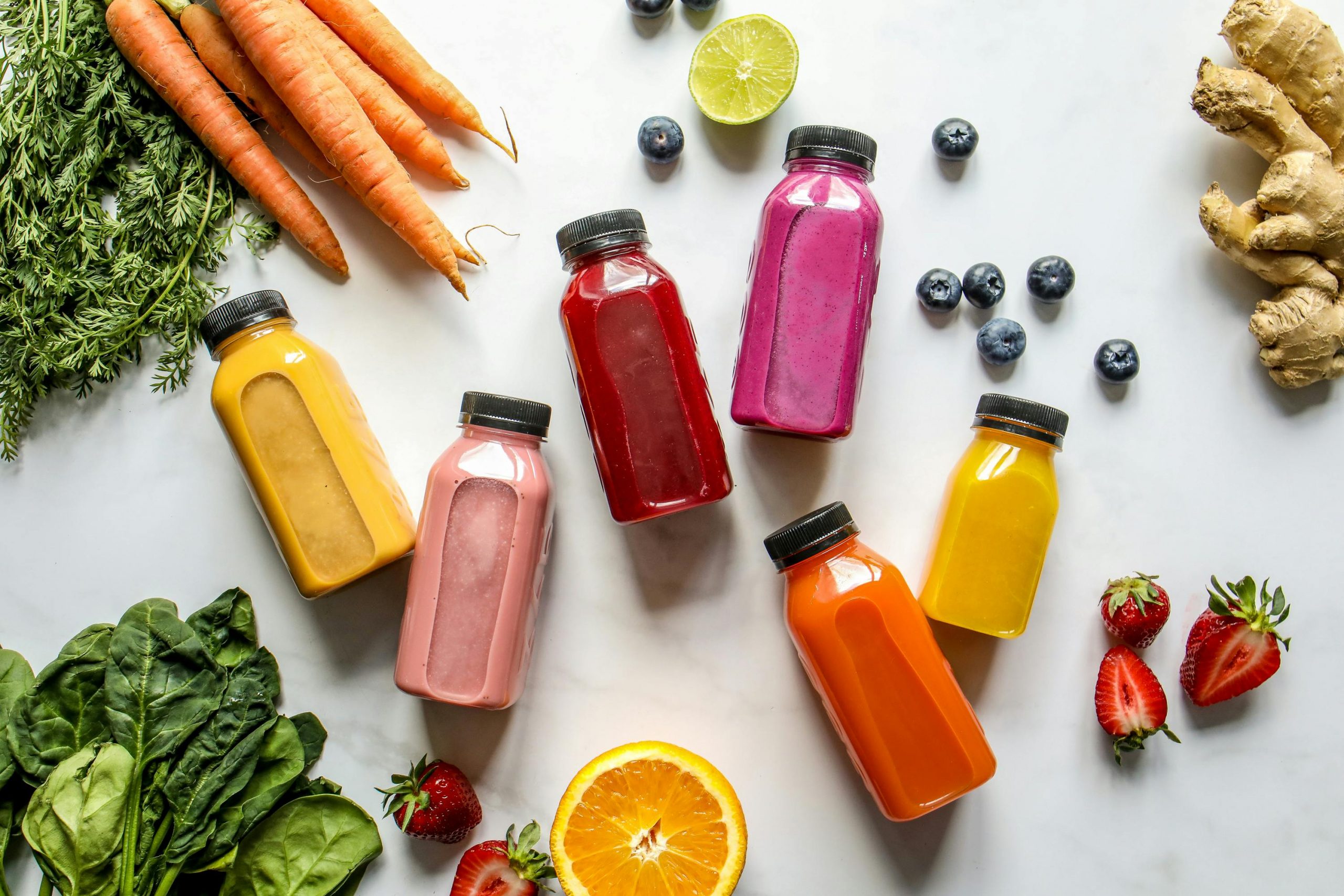 colorful smoothies in bottles, vegetables, and fruits