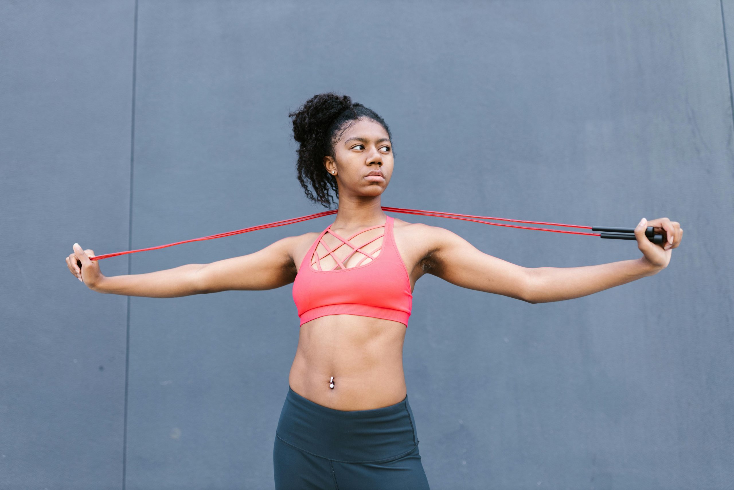 woman in gym clothing stretching a jump rope